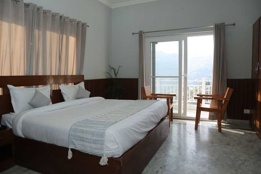 Wake up in a cozy bedroom with a balcony that frames the Himalayas